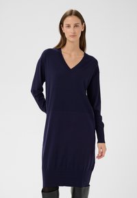 Marineblaues Strickkleid mit V-Ausschnitt, langen Ärmeln und geripptem Saum. Hergestellt aus weichem Material, mit lockerem Schnitt und minimalistischem Design.