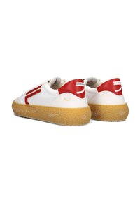 Sneakers bianchi con accenti rossi e una suola in gomma texturizzata. Presentano una tomaia liscia, punta arrotondata e dettagli del logo sul tallone.