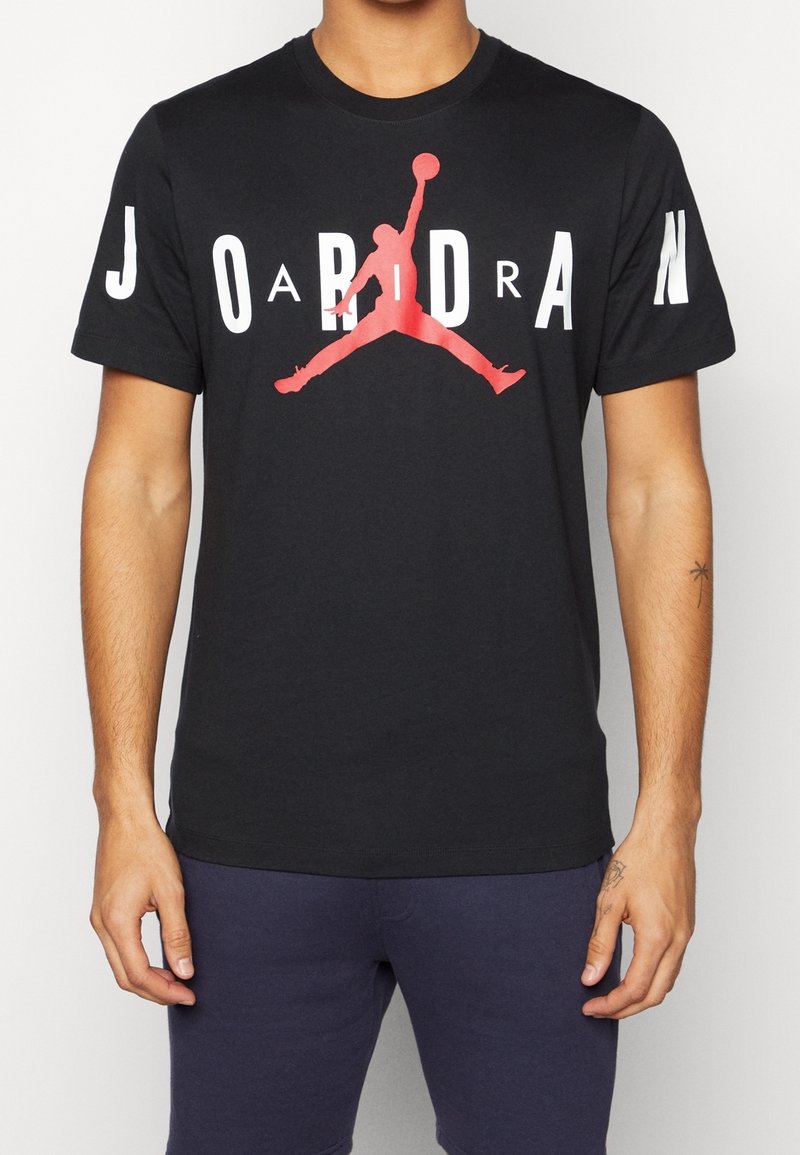 Czarna bawełniana koszulka z krótkim rękawem z czerwonym logo Jumpman i białym napisem "JORDAN". Okrągły dekolt, krótki rękaw i standardowy krój.