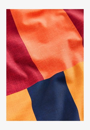 Textil med stora block av röd, orange, gul och mörkblå i en texturerad tyg, som visar ett rutmönster.