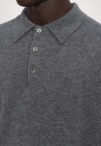 Gray knitted polo shirt with a folded collar, featuring three gray buttons. Close-up view of fabric texture and button details.
