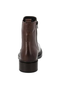 Brązowy skórzany botek za kostkę z okrągłym noskiem, zamkiem błyskawicznym z boku i niskim obcasem w kształcie bloku; gładka tekstura z delikatnym połyskiem. Widok z tyłu.