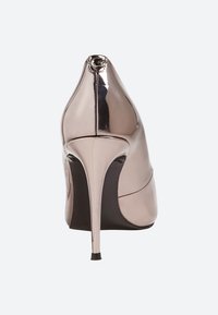 Błyszczący metaliczny but na wysokim obcasie typu stiletto widziany z tyłu, z ostrym czubkiem obcasa i gładką powierzchnią.