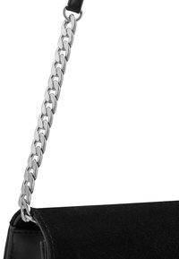 Czarna torebka zamszowa o wyrazistym kształcie, z grubym srebrnym łańcuchem jako uchwytem oraz gładkimi skórzanymi akcentami.