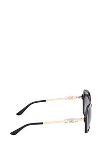 Zonnebril met zwarte monturen, gradient lenzen, gouden metalen pootjes met geometrische accenten en zwarte rubberen uiteinden voor comfort.