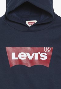 Marinblå hoodie med en stor röd och vit Levi's-logotyp på framsidan, med en klassisk känguruficka och huva med dragsko.