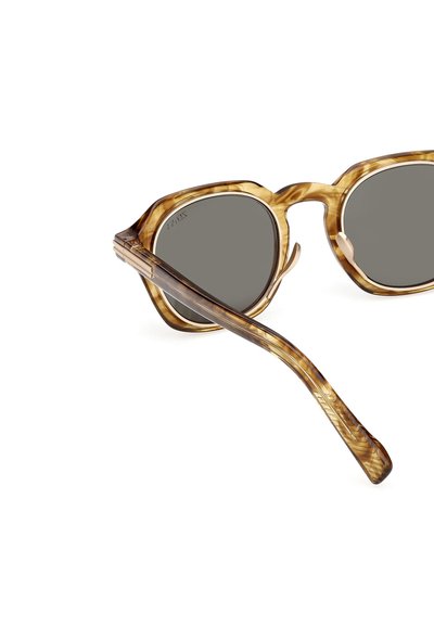 Solbriller med en stor, klar stel i skildpaddeskal, mørkegrå linser og teksturerede stænger med et diskret mønster.