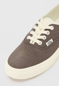 Brune kanvas sneakers med off-white snøring og såle. Har merkelogo på siden, teksturert mønster på overdelen og glatt gummisåle.