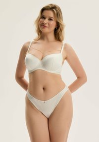 Biały szlafrokowy zestaw bielizny koronkowej z usztywnianym biustonoszem z fiszbinami i ozdobnym łańcuszkiem, w połączeniu z dopasowanym wysokim thongiem.