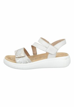 White open-toe sandal with adjustable straps, cushioned beige footbed, textured front strap, and thick white rubber sole.
