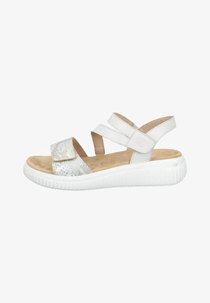 White open-toe sandal with adjustable straps, cushioned beige footbed, textured front strap, and thick white rubber sole.