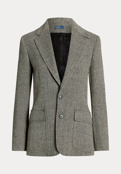 Blaser com padrão pied-de-poule em preto e branco, apresentando lapela em bico, dois botões e dois bolsos frontais. Forro interior preto suave.