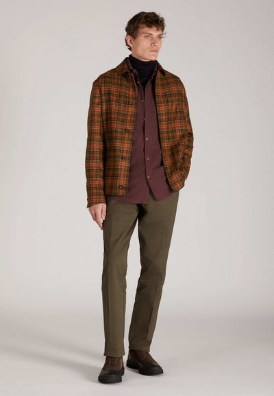 Casual outfit voor heren: geruite bruine en oranje jas, bordeauxrode shirt, olijfgroene broek en bruine schoenen. Eenvoudig ontwerp, knoopjesjas.