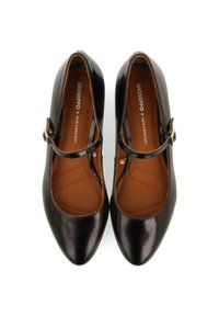 Zapatos Mary Jane de charol negro con puntera puntiaguda, una tira delgada alrededor del tobillo y un interior marrón liso.