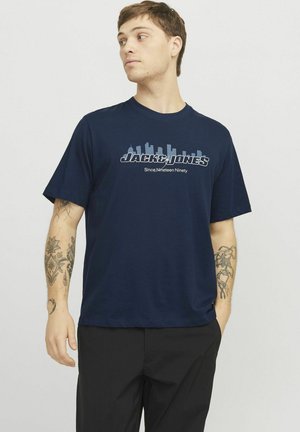 Navyblauwe katoenen t-shirt met een grafische print van een skyline en de tekst "JACK&JONES Sinds Negentien Negenentig" in lichtgrijs. Korte mouwen.