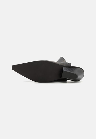 Chaussure noire à talons avec un bout pointu et une semelle lisse. Présente un dessus texturé et un accent brillant sur le talon.