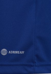 Tessuto atletico blu con una consistenza liscia. Logo "AEROREADY" stampato in bianco, accompagnato da un'icona del globo verso il fondo.