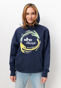 Navyblauer Hoodie aus Baumwolle, mit einer Fronttasche und einem grafischen Logo-Design mit kreisförmigen Akzenten in Grün und Gelb.