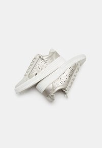 Metallic silver sneakers with perforated design, white rubber sole, lace-up front, and side zipper detail. Smooth texture with a slight sheen.