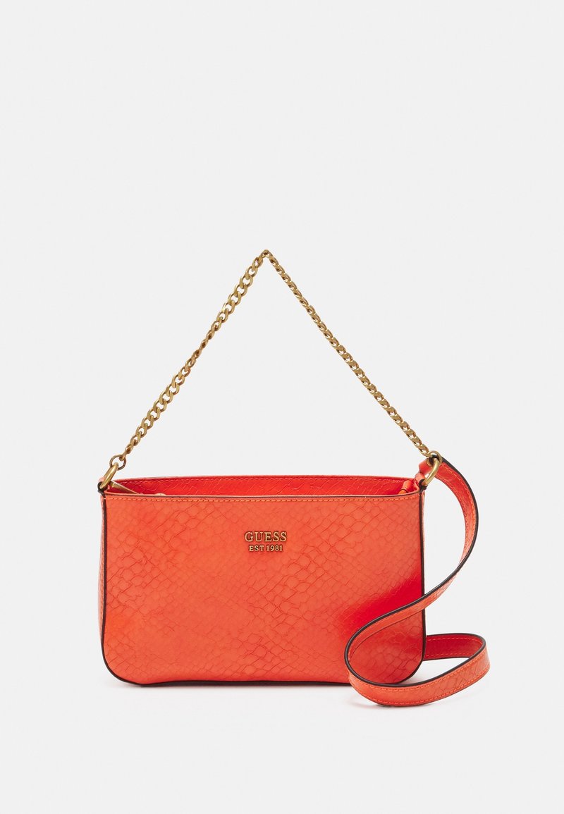 Petit sac à main orange texturé avec anse chaîne dorée et longue bandoulière orange, marqué GUESS en lettres dorées sur le devant.