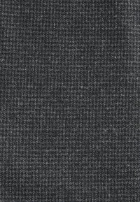 Sötétszürke szövet finom kockás mintával, amelyet világosabb szürke vonalak és texturált szálak metszése hoz létre.
