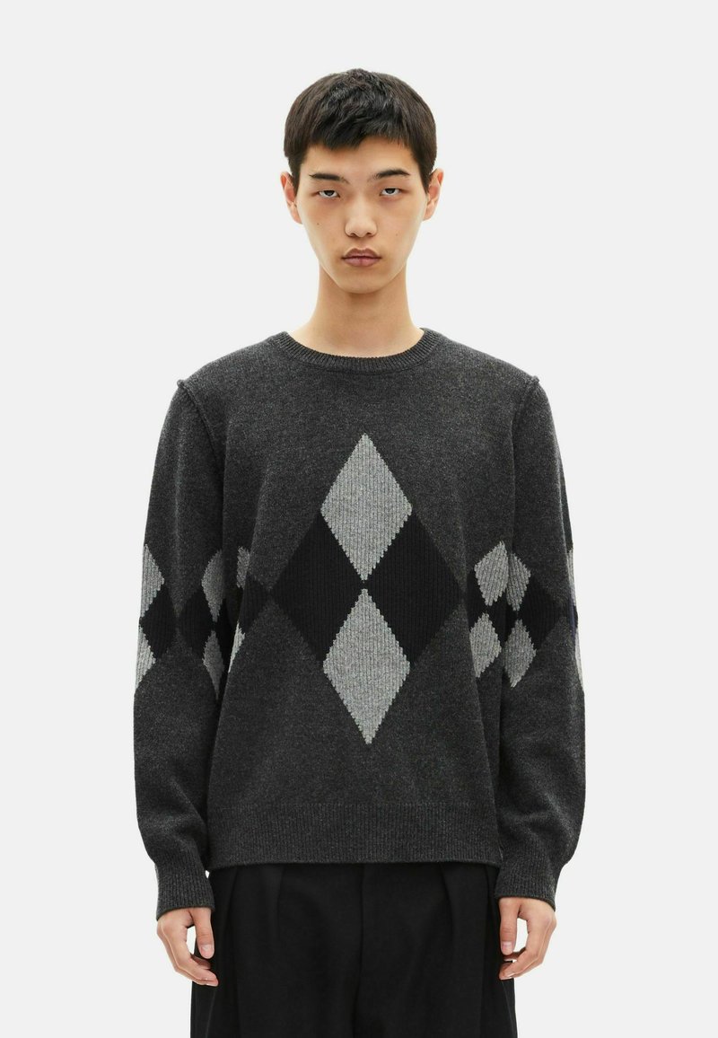 Suéter de punto gris con un patrón de diamante en negro y gris claro. Cuello redondo clásico y mangas largas, con puños y dobladillo acanalados.