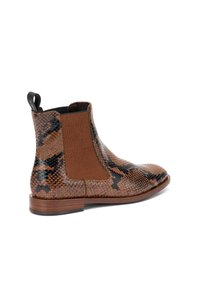 Botín Chelsea de cuero con estampado de serpiente en tonos marrones y negros, con paneles laterales elásticos y tirador, que presenta una superficie texturizada y suela plana de madera.