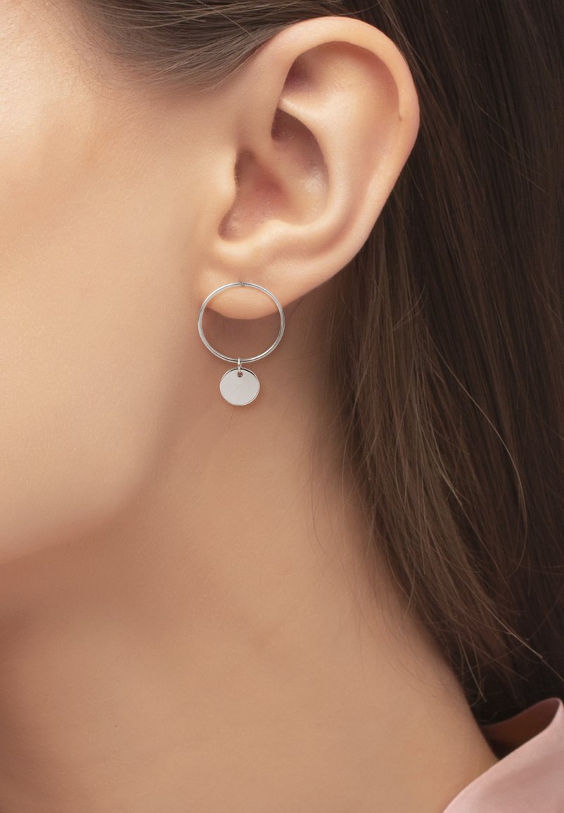 Silberne Creolen mit einem kreisförmigen Design und einem kleineren runden Tropfenakzent. Glatte Textur mit polierter Oberfläche.