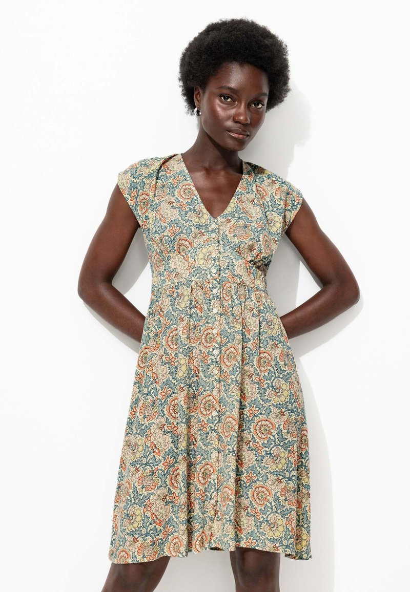 Robe à imprimé floral en bleu, crème et orange, avec un col en V, des manches courtes et une taille cintrée qui se termine par une jupe évasée. Texture de tissu douce.