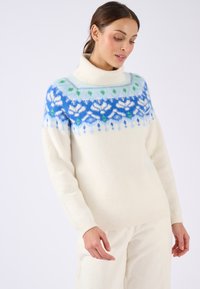 Maglione color crema con colletto alto a coste, caratterizzato da un motivo a yoke blu e verde. Materiale morbido e tessurizzato. Maniche lunghe.