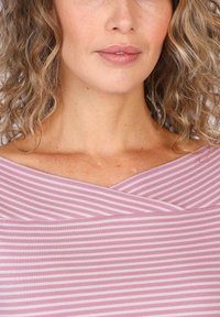 Helles pinkes Oberteil mit weißen horizontalen Streifen, das über einen gekreuzten Ausschnitt und eine weiche Textur verfügt. Das Design hat eine lockere Passform und lässt die Schlüsselbeine sichtbar.