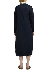 Marineblaue Langarmkleid mit geradem Schnitt, gerippten Akzenten und seitlichen Schlitzen. Hergestellt aus leichtem Stoff mit lässiger Passform.