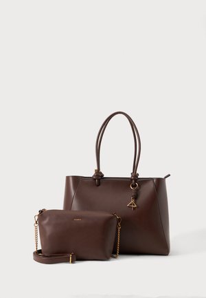 Zwei dunkelbraune Ledertaschen: eine große Tote mit doppelten Griffen und einem kleinen goldenen Anhänger, eine kleinere Umhängetasche mit einem goldenen Kettenriemen.