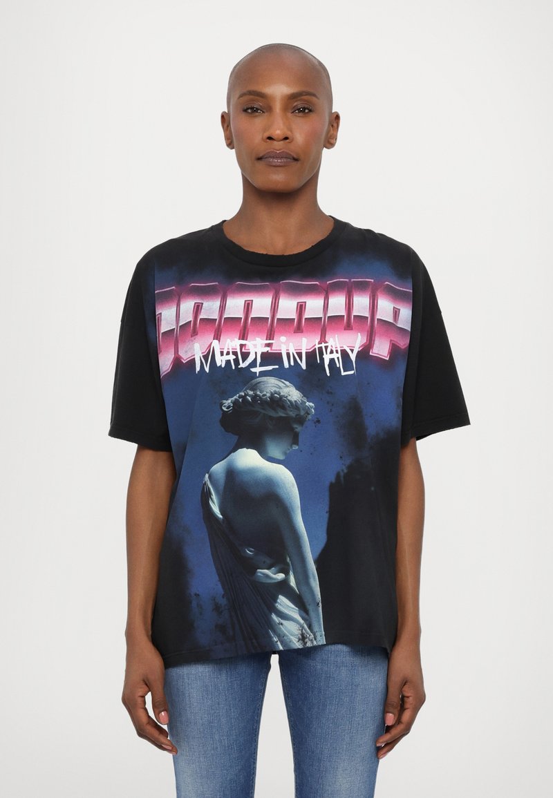 Camiseta gráfica negra con diseño de estatua azul, texto "HECHO EN ITALIA" en rosa, corte oversized, mangas cortas y cuello redondo.