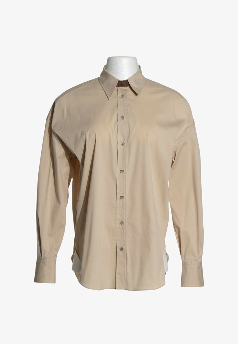 Chemise beige à manches longues avec boutons et col classique, présentée sur un buste de mannequin blanc sur fond uni.