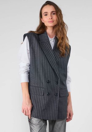 Double-breasted vest in dark gray fabric with white pinstripes, featuring wide lapels, flap pockets, and a relaxed fit.