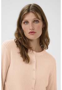 Hellrosa gerippter Cardigan mit rundem Ausschnitt, einer Knopfleiste vorne und einem strukturierten Strickmuster.