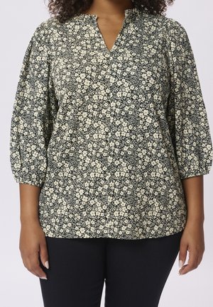 Zwart-witte bloemenblouse met een v-hals en pofmouwen. Zachte stof met een klein bloemenpatroon in het geheel.