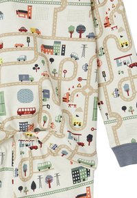 Children's pajamas with a colorful city road map print featuring cars, buses, buildings, trees, traffic lights, and construction equipment.