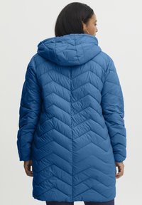 Padded coat w średnim niebieskim kolorze z kapturem, z lamowanym wzorem w zygzak i długimi rękawami, wykonany z lekkiego, wodoodpornego materiału.