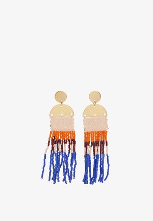 Okrągłe kolczyki w odcieniu złota z górną częścią w kształcie półkola oraz wielokolorową koralikową frędzlem w beżowych, pomarańczowych, brązowych i niebieskich nitkach.