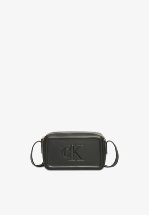 Zwarte rechthoekige crossbodytas met reliëflogo "cK" op het voorpaneel en verstelbare schouderriem.