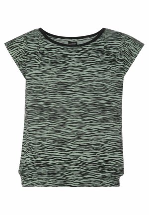 Zielona bluzka z krótkim rękawem w czarny, abstrakcyjny wzór, zestawiona z szarymi szortami i czarnymi sportowymi butami na wysokiej podeszwie. Gładki materiał, luźny krój.