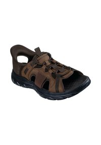 Sandal de múltiples paneles en color marrón con diseño abierto, que cuenta con una suela acolchada, cordones ajustables y secciones recortadas para mayor transpirabilidad.