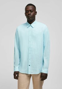 Lichtblauw langharig overhemd van linnen stof, met een button-down kraag, voorste knopen en een rechte zoom. Textuurdetail op het oppervlak.