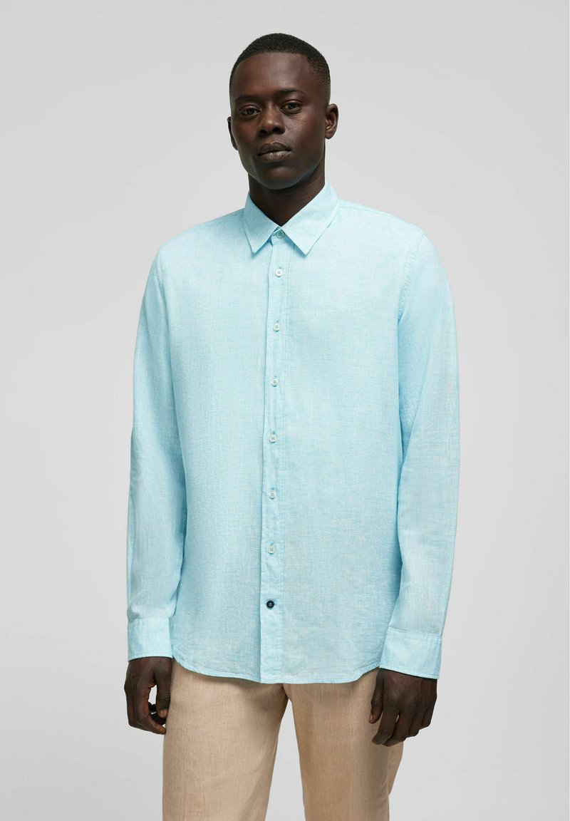 Lichtblauw langharig overhemd van linnen stof, met een button-down kraag, voorste knopen en een rechte zoom. Textuurdetail op het oppervlak.