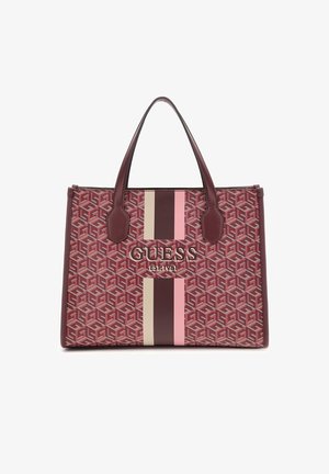 Prostokątna bordowa torba typu tote z geometrycznym wzorem, pionowe różowe i beżowe paski, podwójne uchwyty i napis "GUESS Est. 1981" z przodu.
