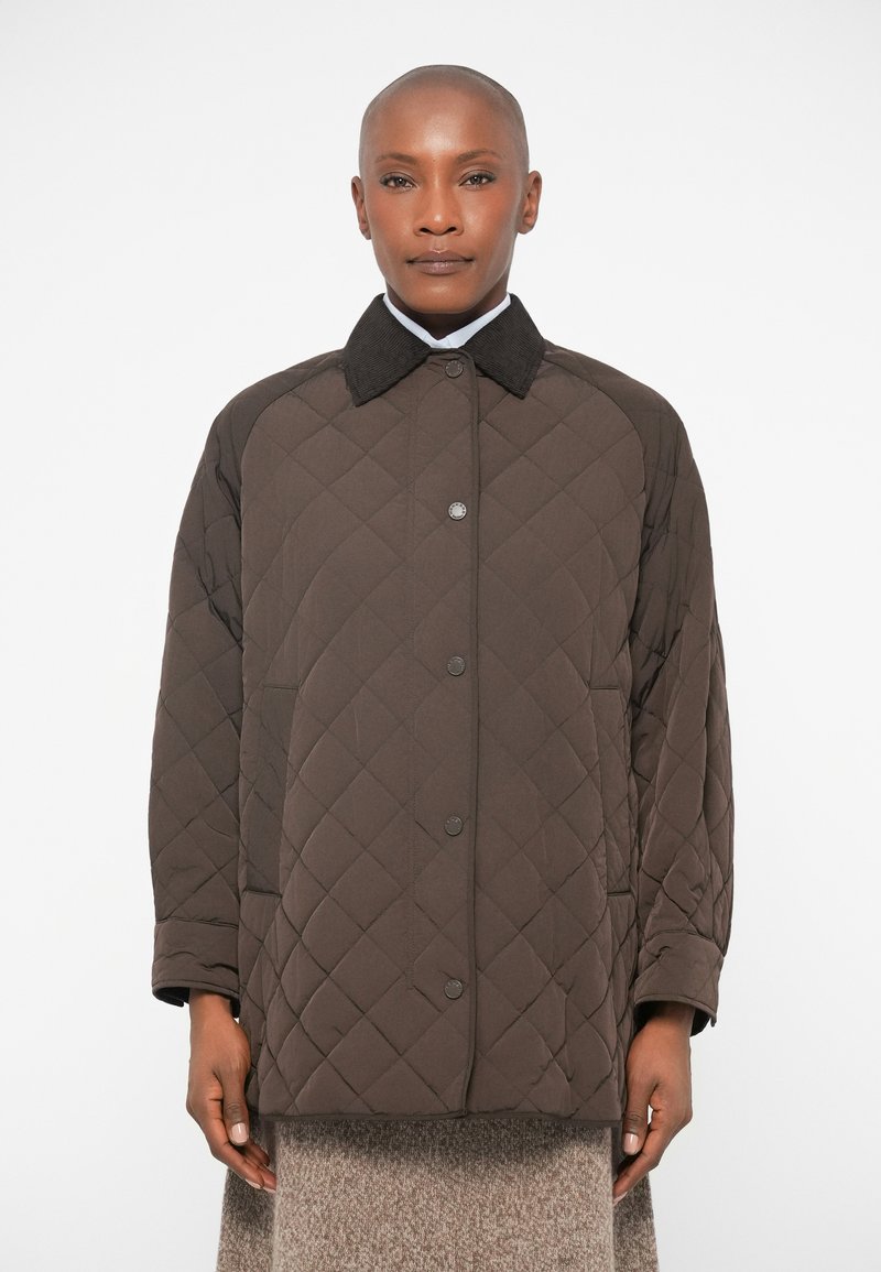 Casaco acolchoado castanho com gola de veludo, fecho frontal de pressão e bolsos laterais. O tecido tem uma textura suave e um padrão de diamante.