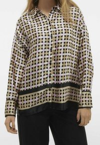 Blusa in satin con motivo a griglia nei colori beige, rosa e nero. Maniche lunghe con chiusura a bottoni e orlo nero nella parte inferiore.