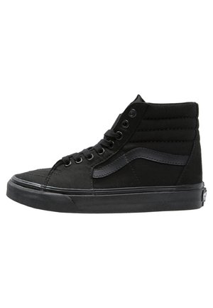 Czarny sneaker za kostkę z wyściełanym kołnierzem, czarne sznurówki, charakterystyczny boczny pasek i gruba gumowa podeszwa.